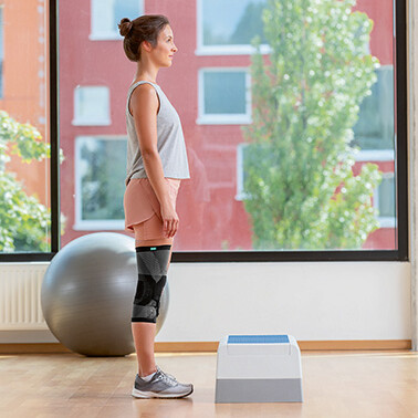 Frau steht vor Step-Aerobic-Brett Frau steht vor Step-Aerobic-Brett