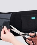 JuzoPro Lumbal Plus with scissors shows how straps can be shortened as required