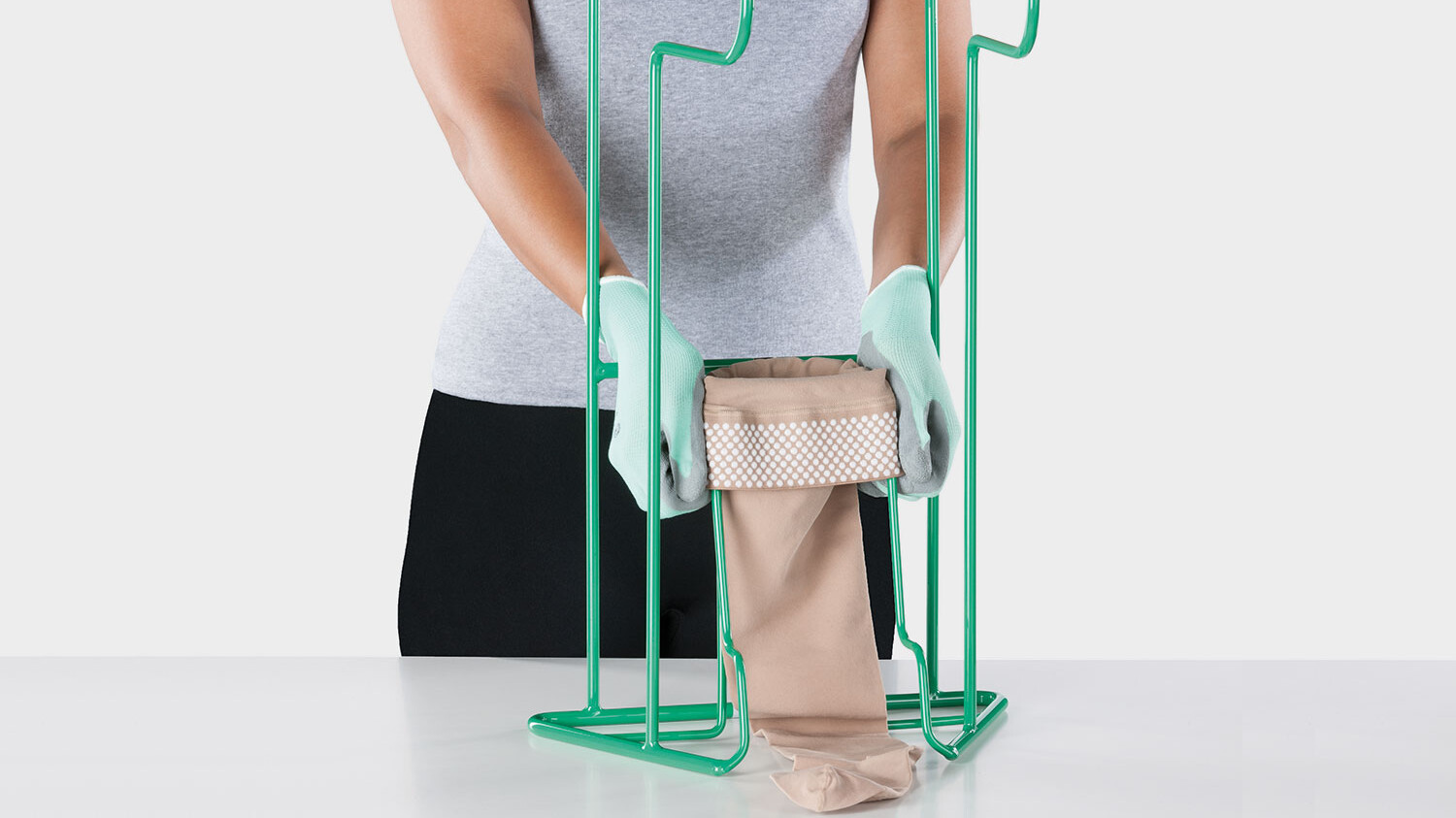 Una persona muestra el dispositivo de ayuda para vestirse Juzo Easy Fit