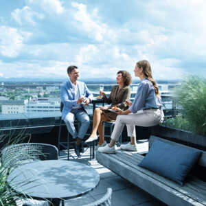 Um homem e duas mulheres estão num terraço e usam meias de compressão Um homem e duas mulheres estão num terraço e usam meias de compressão