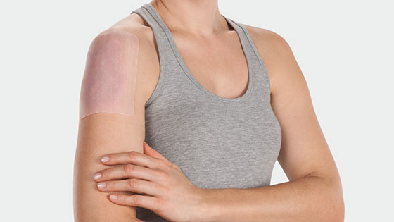 A woman is wearing the Juzo ScarPad on her shoulder