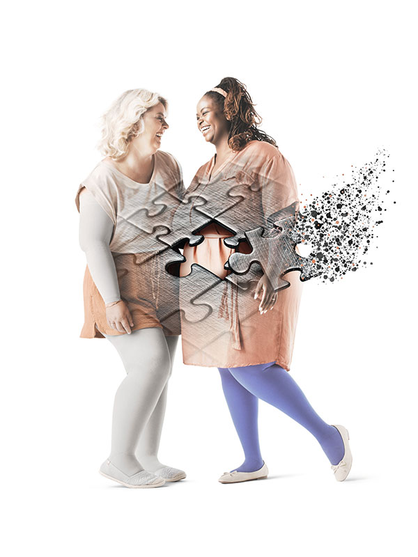 Zwei Frauen im lachen gemeinsam. Sie tragen Kompressionsstrümpfe. Im Vordergrund Puzzleteile, die ineinander gelegt werden.